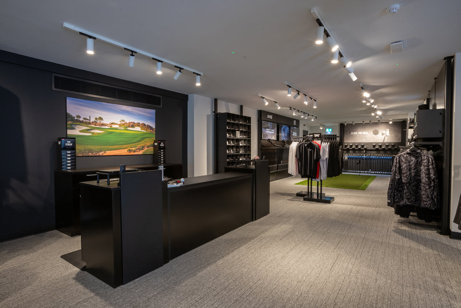 PXG golf store interior with clothing racks and a reception desk.