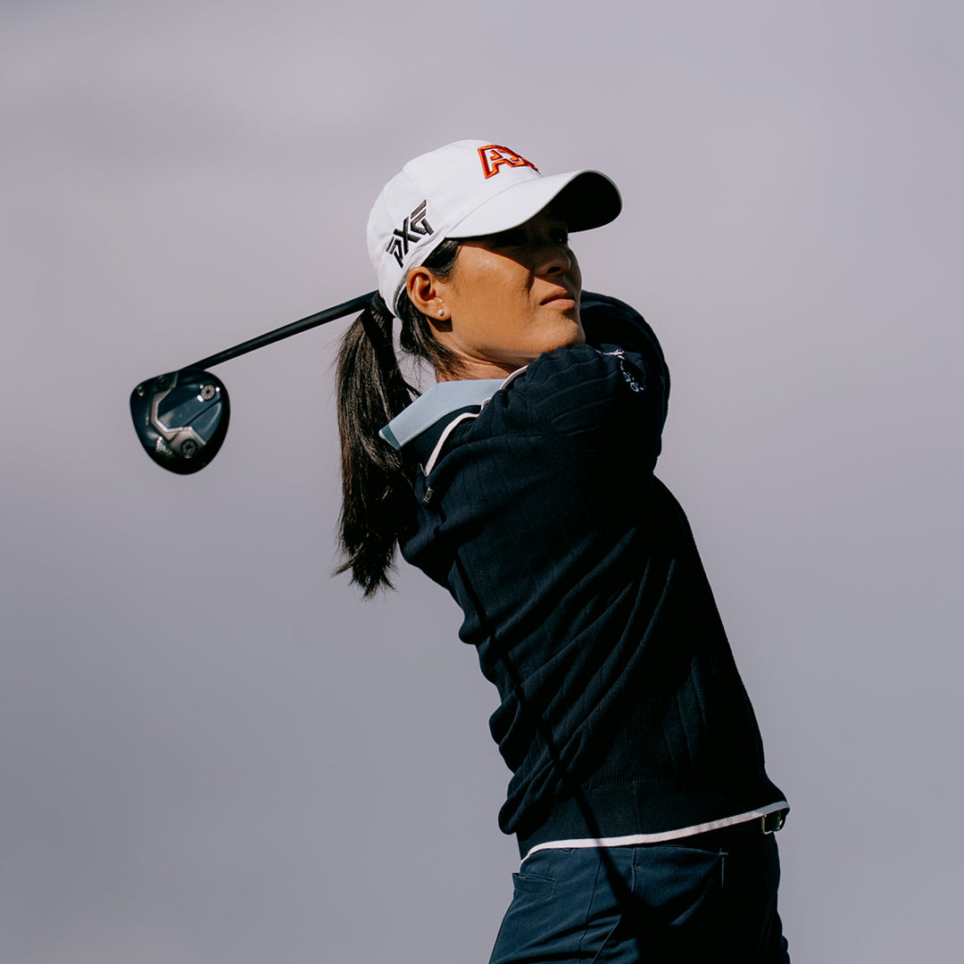LPGA Tour Pro Celine Boutier wearing a PXG Golf Hat against a white sky.