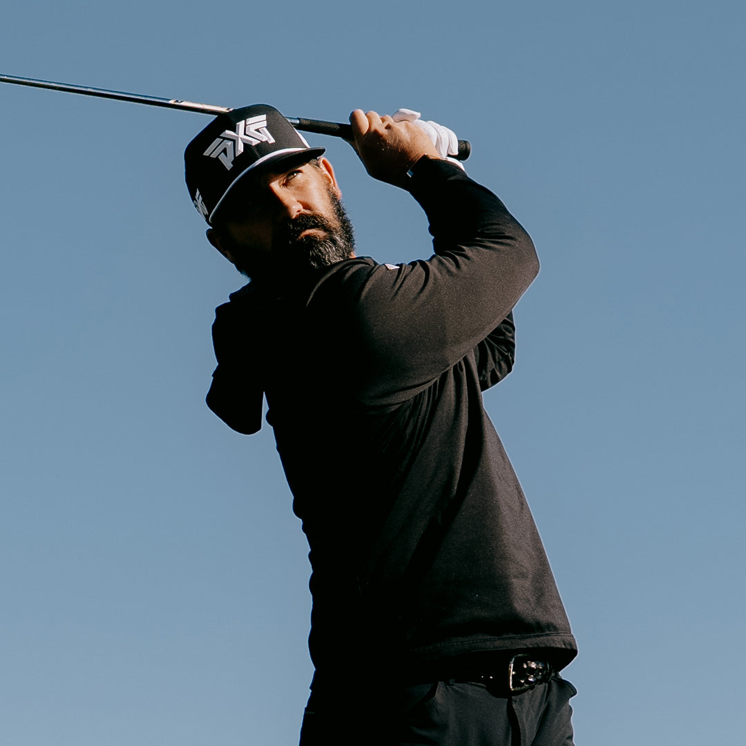 PGA Tour Pro Chad Ramey wearing a PXG Golf Hat against a blue sky.
