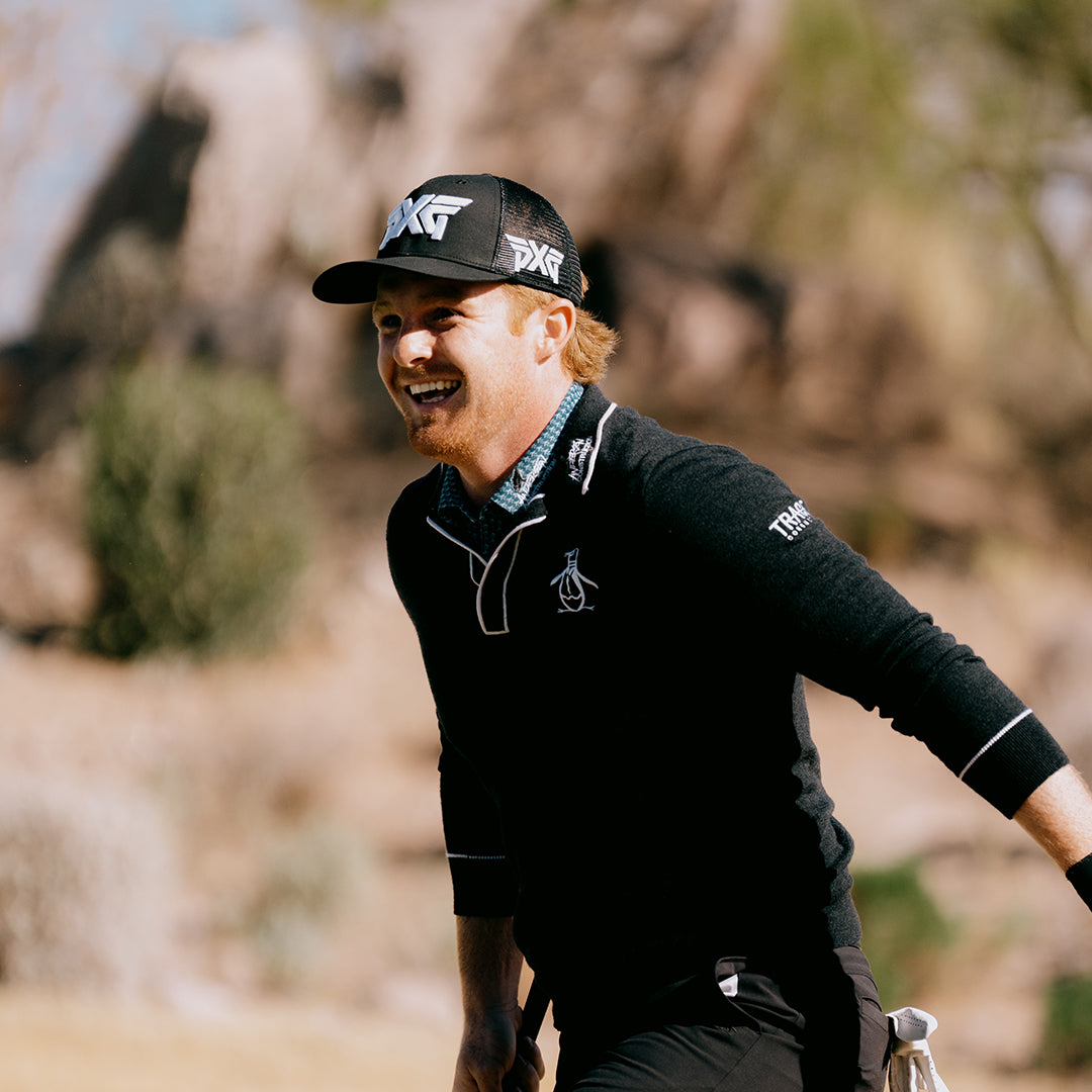 Pro Mason Andersen wearing a PXG Hat and swinging a golf club on a golf course.