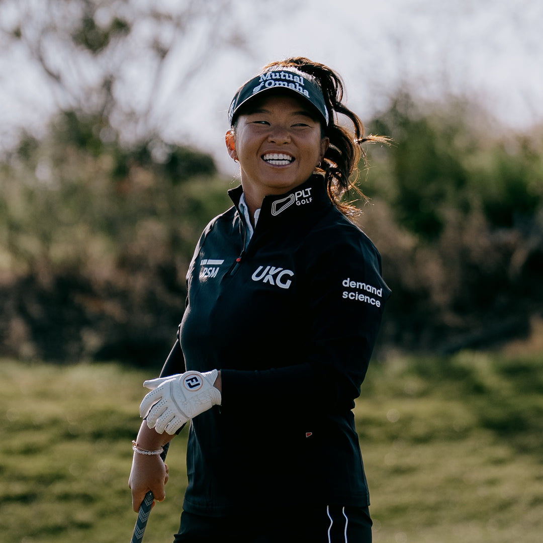 LPGA Tour Pro Megan Khang smiling on a golf course.