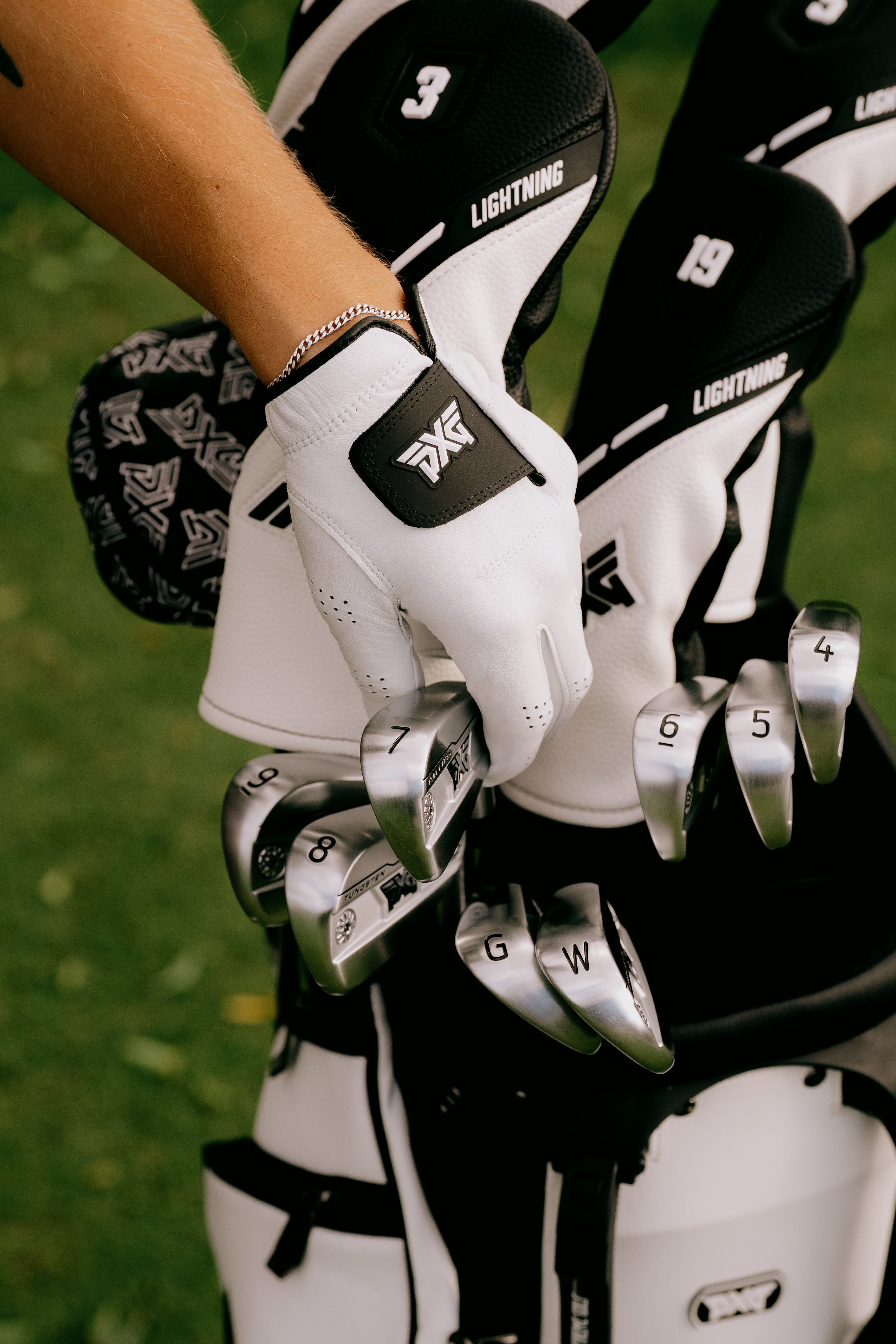 Golf clubs with gloves on a grassy background