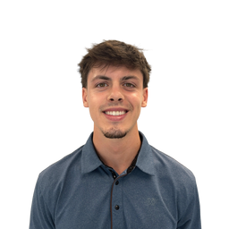 A smiling young man with short brown hair and light stubble, wearing a textured slate blue polo shirt, photographed against a solid white background.